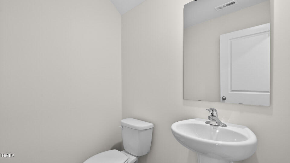 27 Red Clover Drive Angier, NC 27501 - Photo 22 of 28 a bathroom with a sink a toilet and mirror