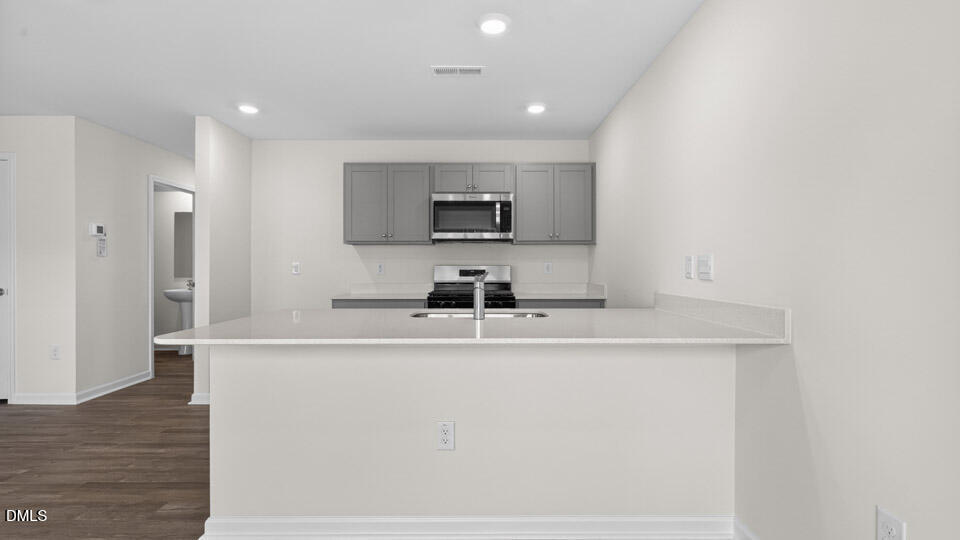 27 Red Clover Drive Angier, NC 27501 - Photo 4 of 28 a kitchen with kitchen island a sink and a refrigerator