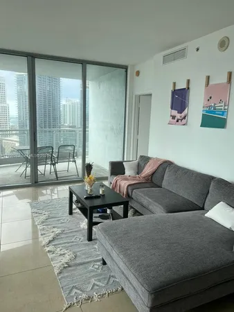 a living room with furniture and large windows
