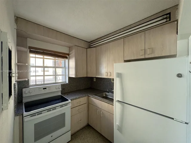 a kitchen with a cabinets and white appliances