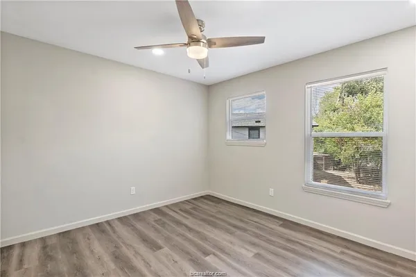 an empty room with a window and a ceiling fan