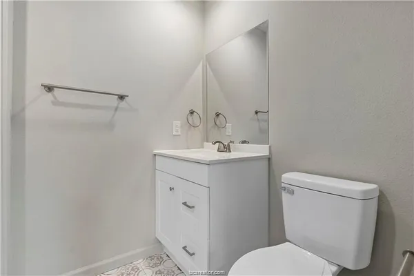 a bathroom with a toilet sink and mirror