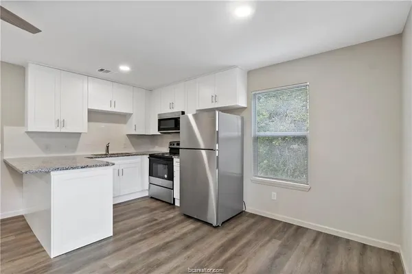 a kitchen with a refrigerator and a stove top oven