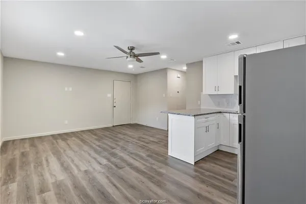 a kitchen with a sink cabinets and wooden floor