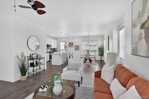 a kitchen with stainless steel appliances kitchen island granite countertop a dining table chairs and a refrigerator