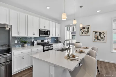 a kitchen with stainless steel appliances granite countertop a sink stove and refrigerator
