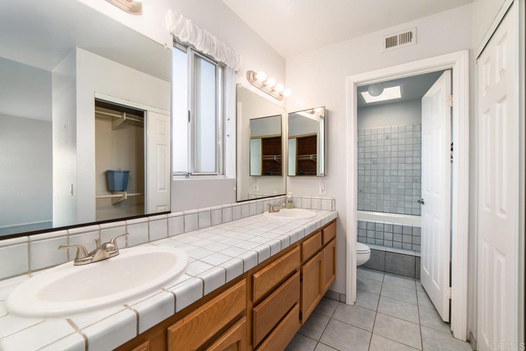 887 Quail Hill Drive San Marcos, CA 92078 - Photo 19 of 22 a bathroom with a granite countertop sink and a mirror