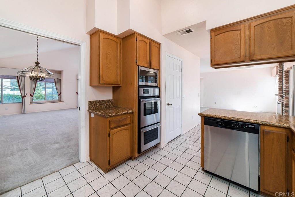887 Quail Hill Drive San Marcos, CA 92078 - Photo 4 of 22 a kitchen with stainless steel appliances granite countertop a refrigerator and a stove