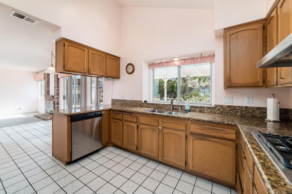 887 Quail Hill Drive San Marcos, CA 92078 - Photo 6 of 22 a kitchen with stainless steel appliances granite countertop a stove a sink and a microwave