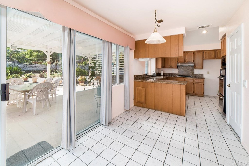 887 Quail Hill Drive San Marcos, CA 92078 - Photo 7 of 22 a kitchen with stainless steel appliances granite countertop a refrigerator and a view of living room