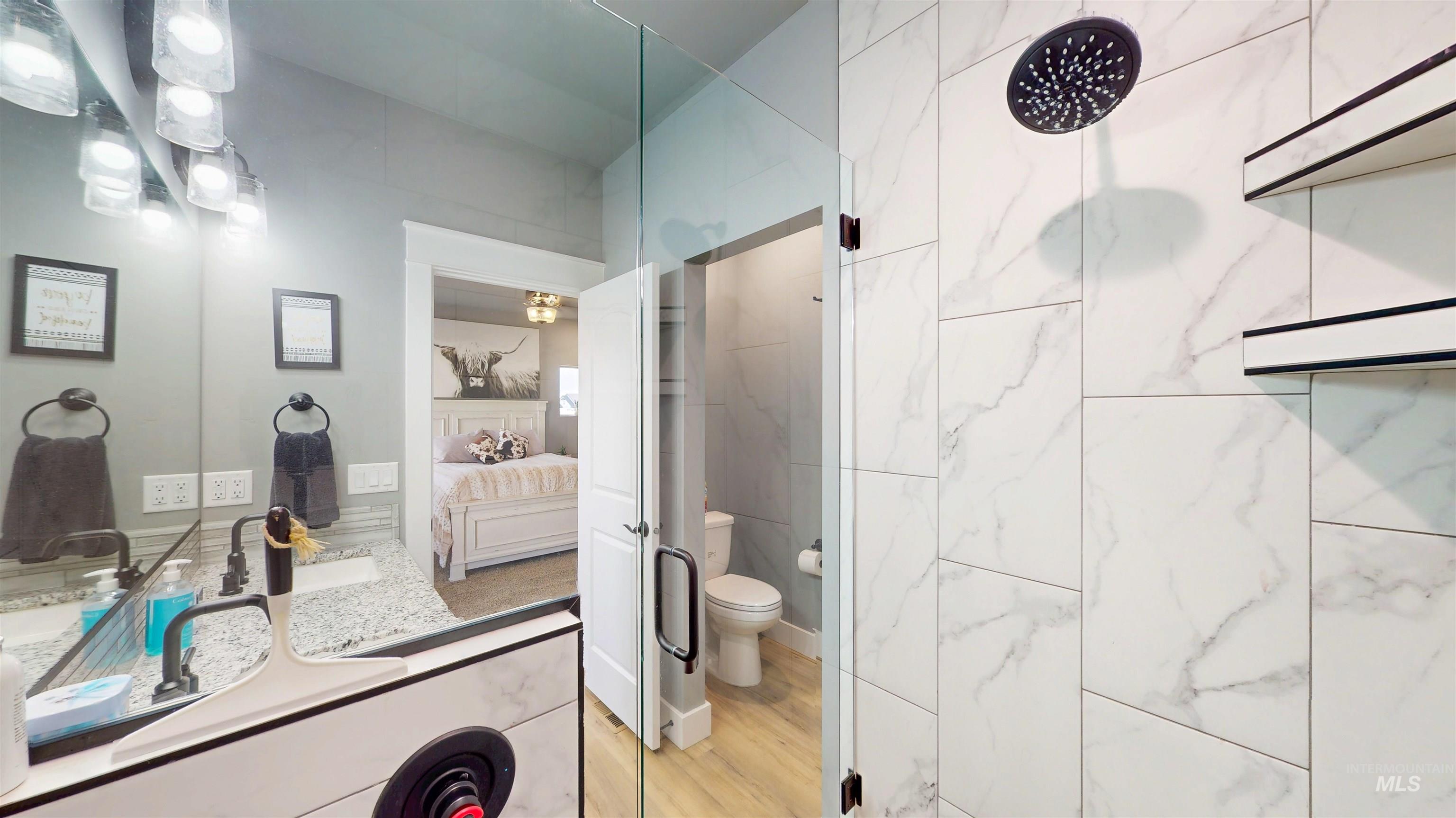 946 Kenbrook Loop Twin Falls, ID 83301 - Photo 15 of 35 Bathroom with ensuite bathroom, vanity, walk in shower, and light wood-style flooring
