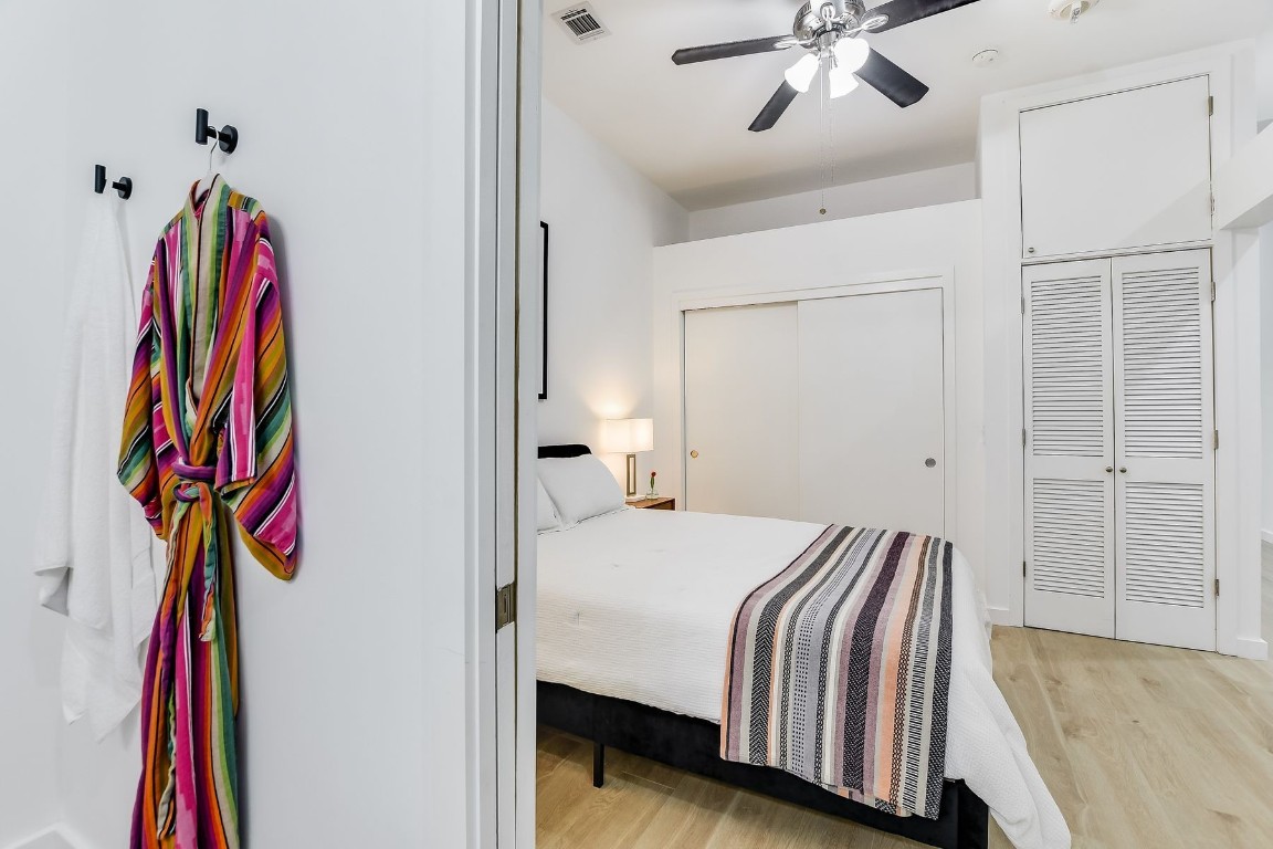 507 Sabine Street, Unit 303 Austin, TX 78701 - Photo 14 of 28 a bedroom with a bed and a chandelier