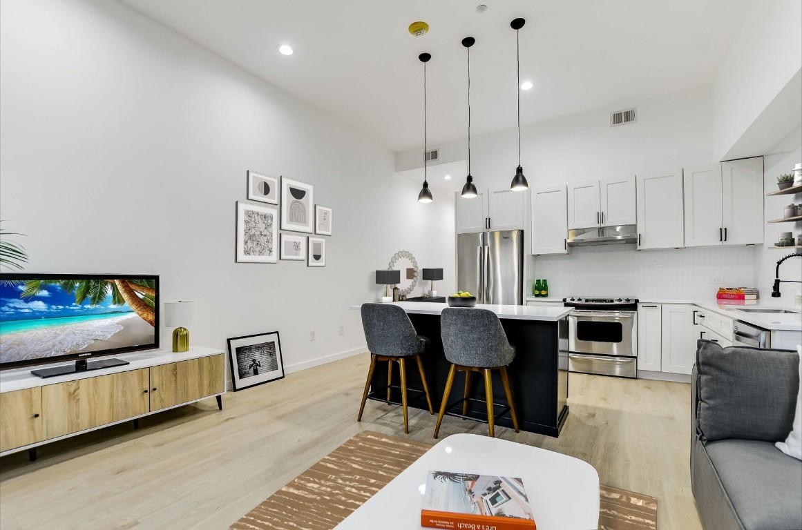 507 Sabine Street, Unit 303 Austin, TX 78701 - Photo 5 of 28 a living room with furniture a flat screen tv and kitchen view