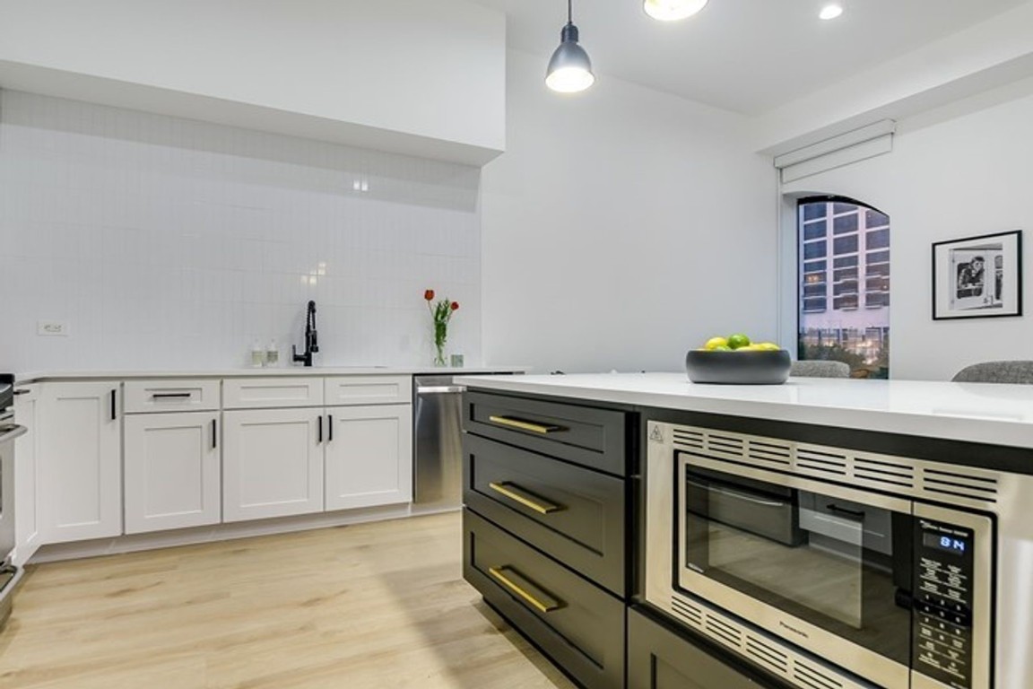 507 Sabine Street, Unit 303 Austin, TX 78701 - Photo 9 of 28 a kitchen with stainless steel appliances a stove cabinets and wooden floor