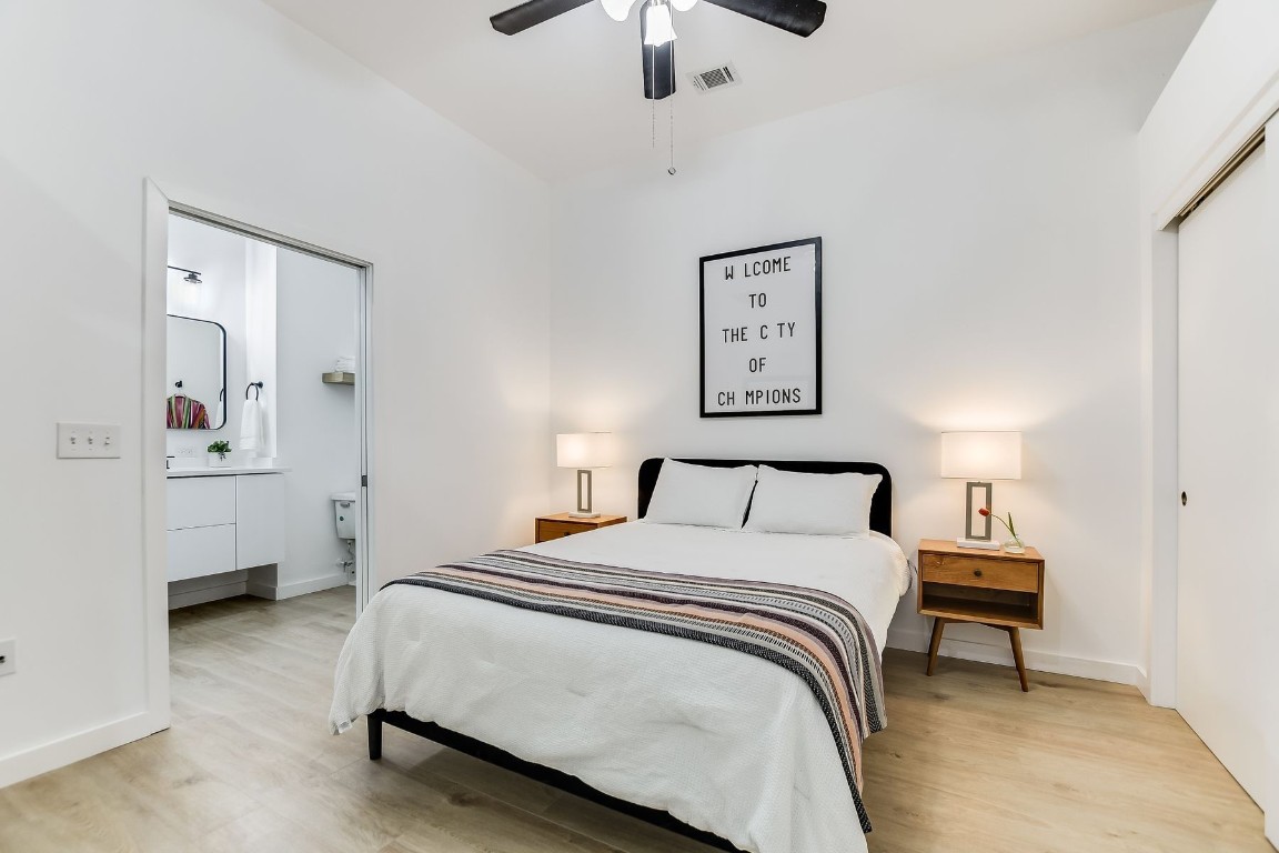 507 Sabine Street, Unit 303 Austin, TX 78701 - Photo 10 of 28 a bedroom with a bed and a chandelier