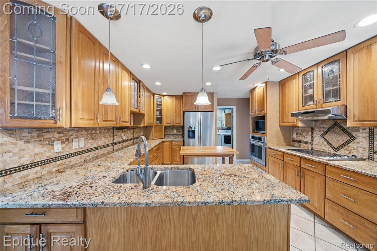 22520 Waltz Road New Boston, MI 48164 - Photo 21 of 43 Kitchen featuring light wood cabinetry, granite countertops, dual basin stainless steel sink, and stainless steel appliances