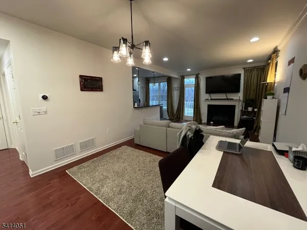 a kitchen with granite countertop wooden cabinets a stove a refrigerator and a sink with wooden floor