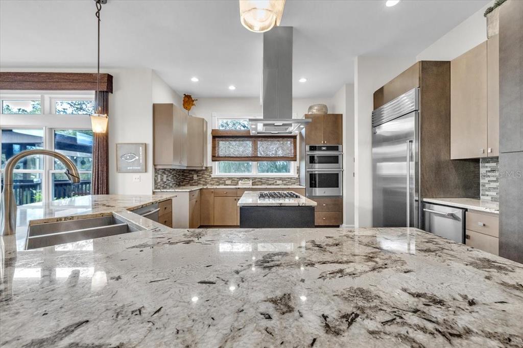 3850 Acline Road Punta Gorda, FL 33950 - Photo 12 of 50 a large kitchen with kitchen island a counter top a stove a refrigerator and a sink