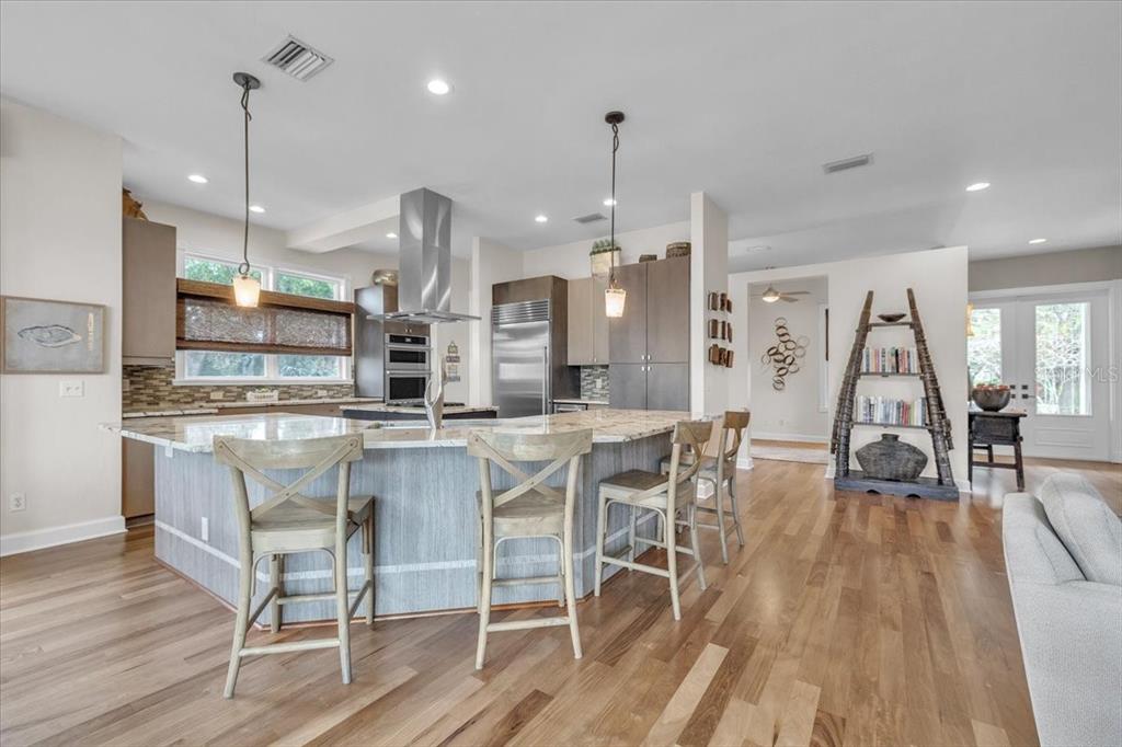 3850 Acline Road Punta Gorda, FL 33950 - Photo 9 of 50 a kitchen with stainless steel appliances kitchen island granite countertop a table chairs and a wooden floor
