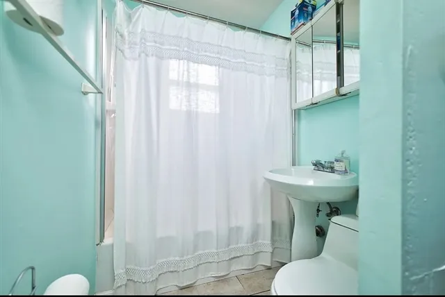 a bathroom with a sink and mirror with toilet