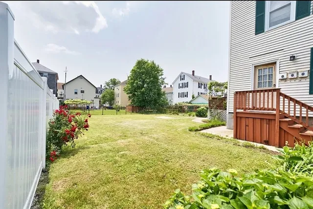 a view of a house with many windows next to a yard