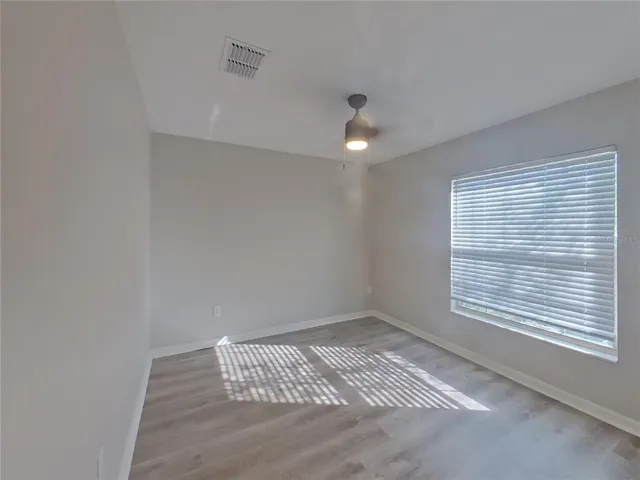 a bathroom with a granite countertop sink a toilet a mirror and shower