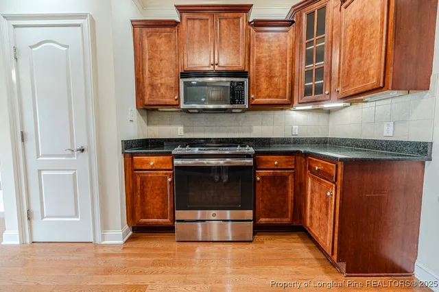 a kitchen with stainless steel appliances granite countertop a stove and a microwave