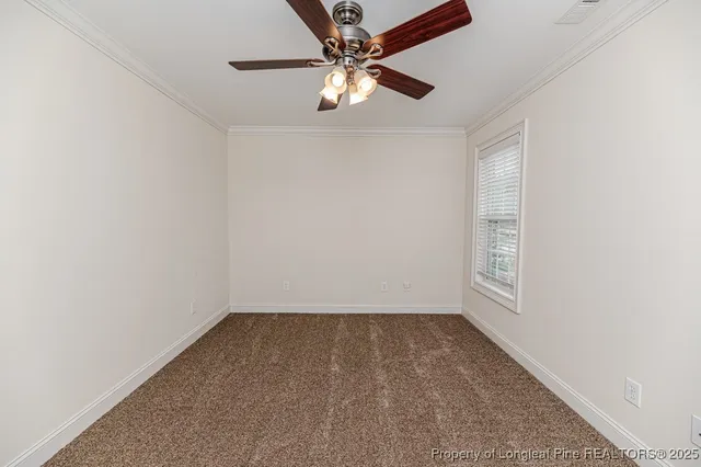 an empty room with fan and windows