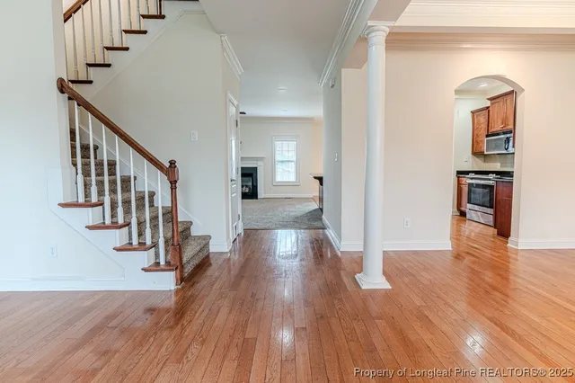 a view of a hallway with wooden floor and staircase