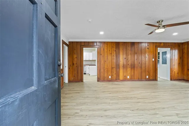 a view of empty room with wooden floor and fan