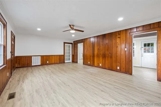 a view of empty room with wooden floor and fan