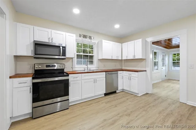 a kitchen with granite countertop a stove top oven and cabinets