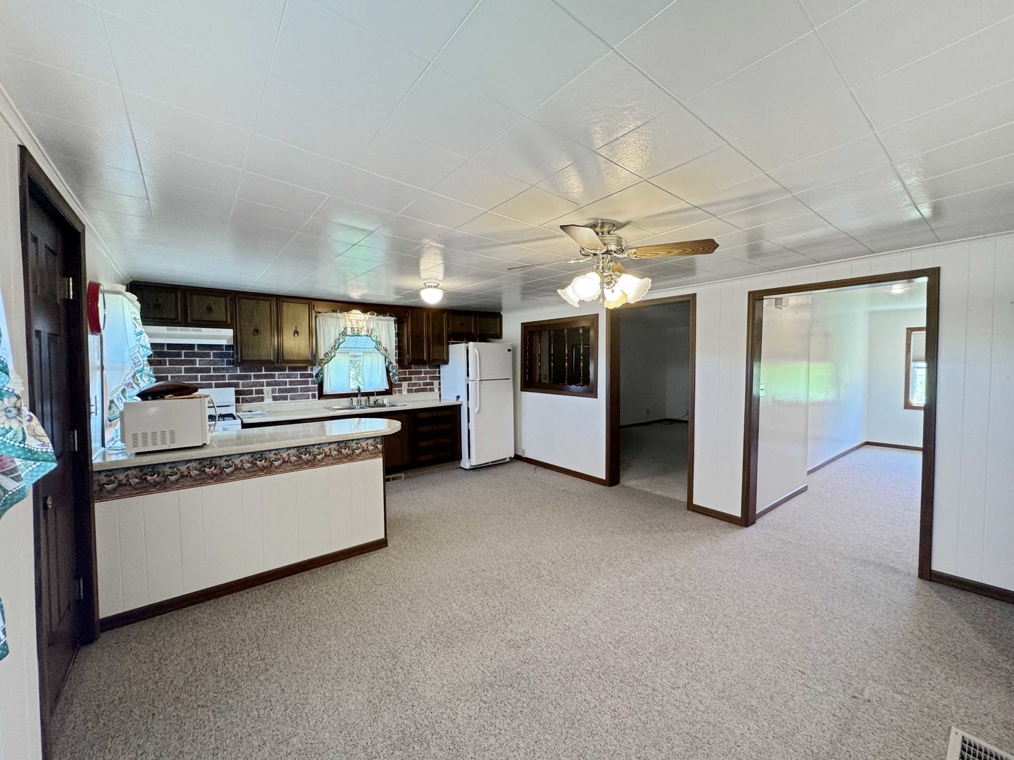 14231 West Kent Road Kent, IL 61044 - Photo 15 of 29 a kitchen with stainless steel appliances kitchen island granite countertop a refrigerator oven a sink dishwasher and white cabinets with wooden floor
