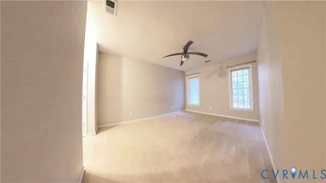 a view of a big room with wooden floor and windows