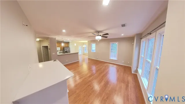 a view of a living room a wooden floor and a kitchen