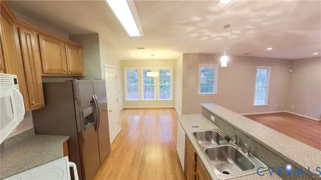a view of a kitchen with a sink and a refrigerator