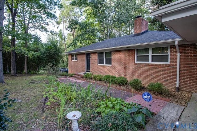 a front view of a house with a yard and potted plants