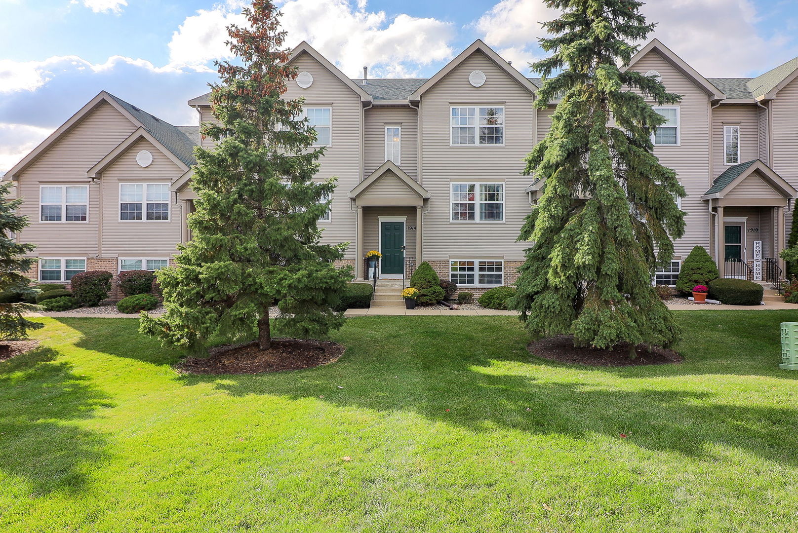 a front view of a house with a yard and trees