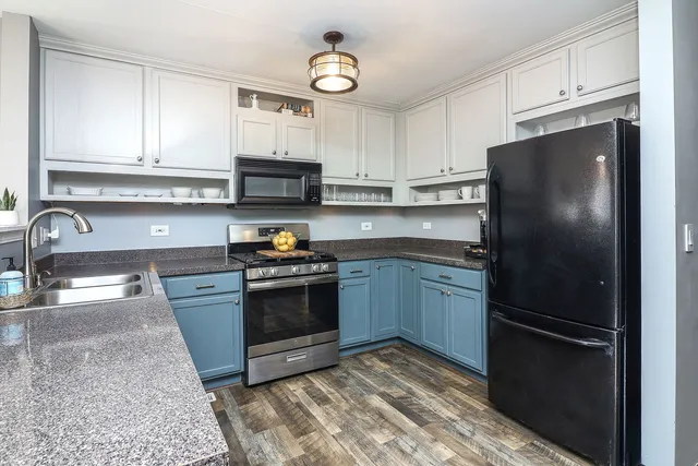 a kitchen with granite countertop a refrigerator stove and sink