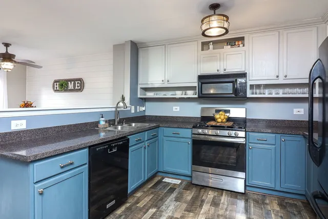 a kitchen with stainless steel appliances granite countertop a sink stove and microwave