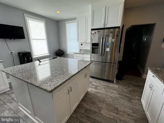 a kitchen with stainless steel appliances granite countertop a refrigerator sink and stove