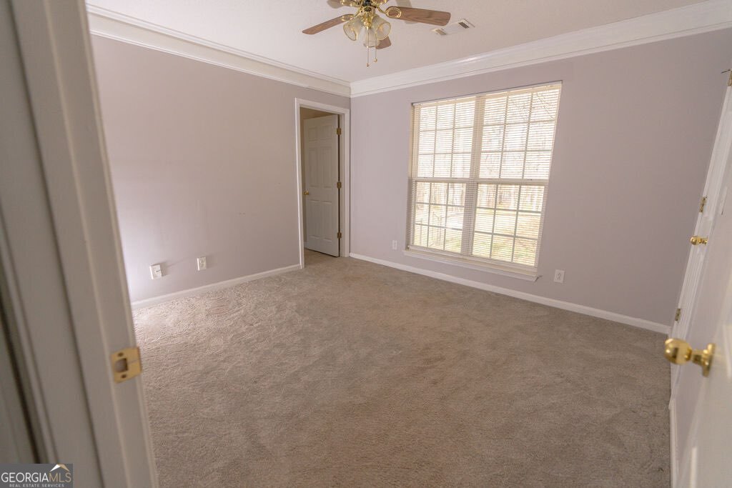 211 Sunfish Trail Southwest Eatonton, GA 31024 - Photo 23 of 40 an empty room with a window and a chandelier fan
