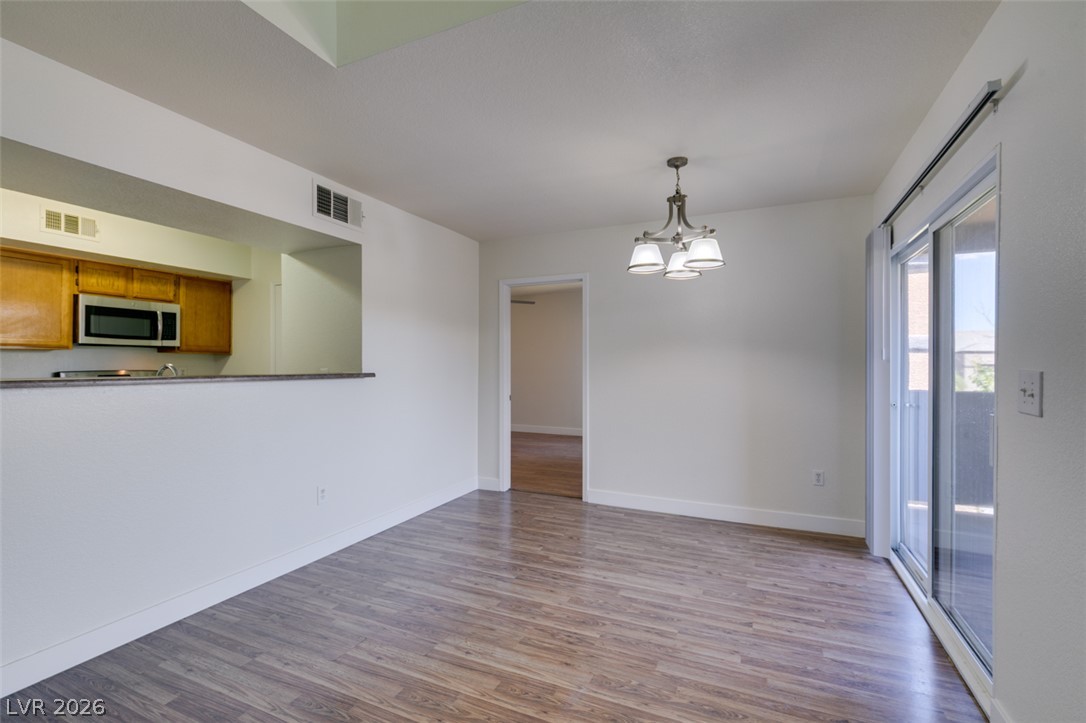 6650 West Warm Springs Road, Unit 2118 Las Vegas, NV 89118 - Photo 5 of 41 A well-lit living area features durable wood-look flooring and convenient sliding glass doors leading to outdoor space.
