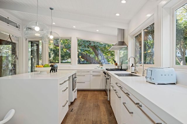 a large white kitchen with a large window