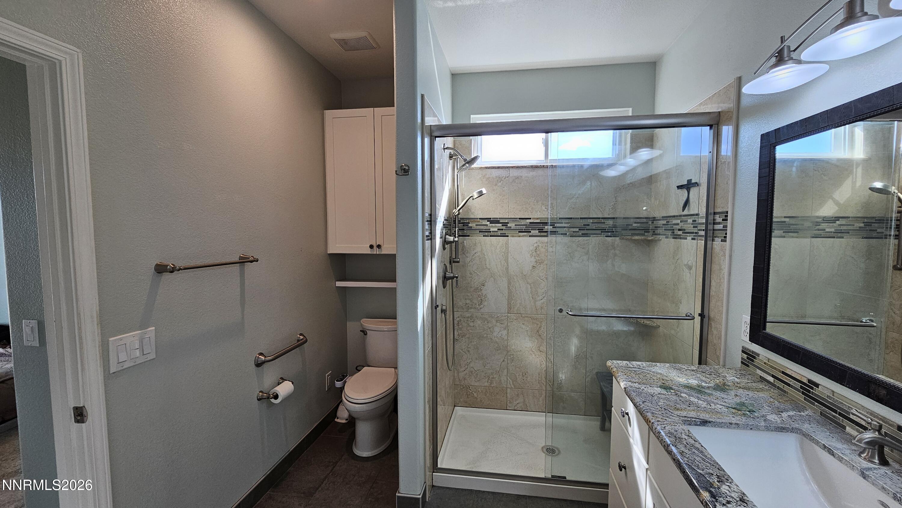 3933 Border Court Reno, NV 89508 - Photo 15 of 36 a bathroom with a granite countertop shower a toilet and a sink