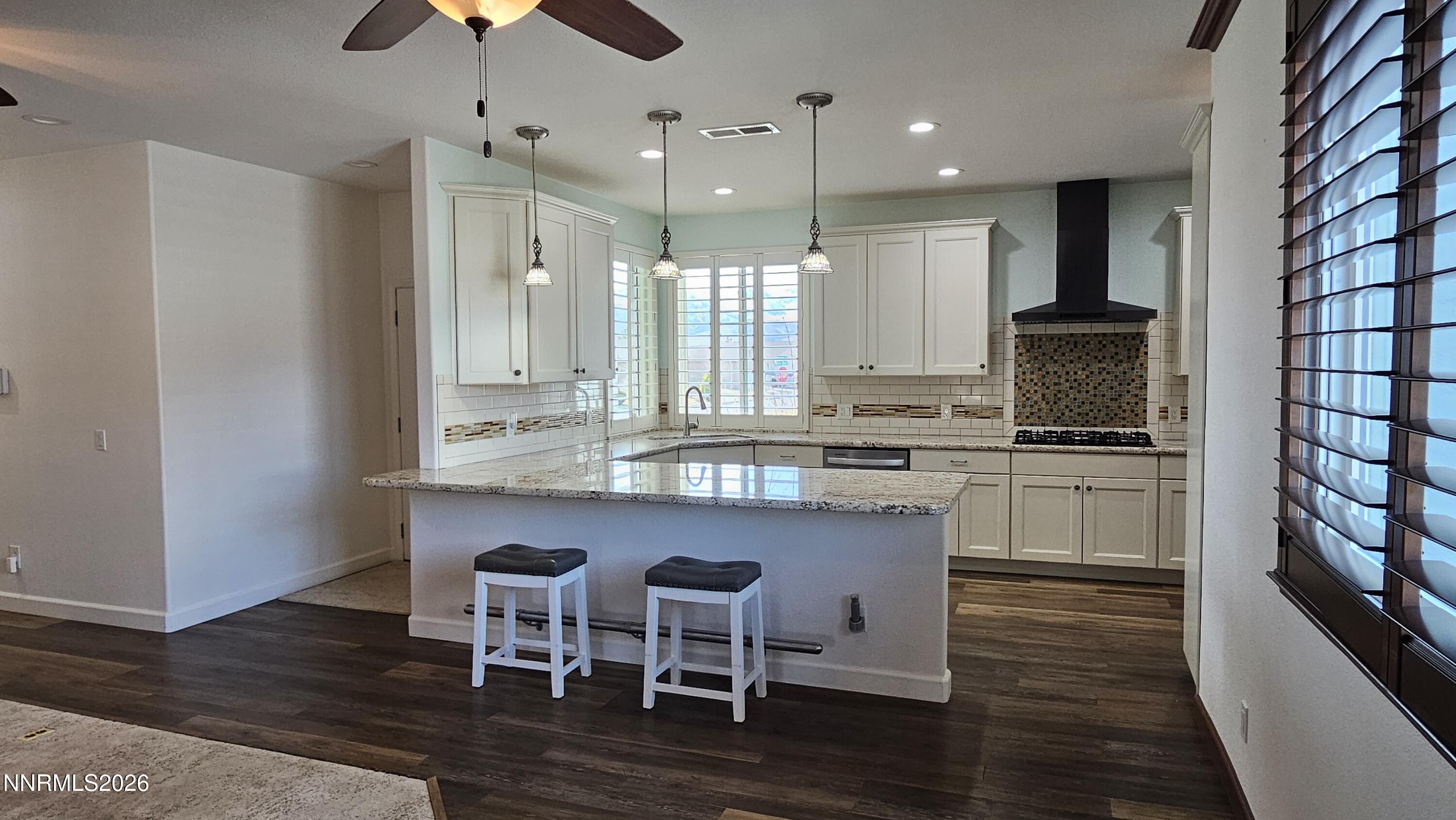 3933 Border Court Reno, NV 89508 - Photo 4 of 36 a kitchen with stainless steel appliances granite countertop a stove top oven a sink dishwasher a dining table and chairs with wooden floor