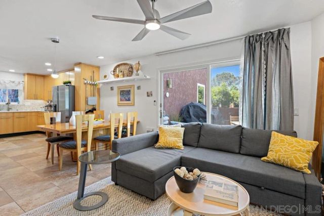 a living room with furniture kitchen view and a large window