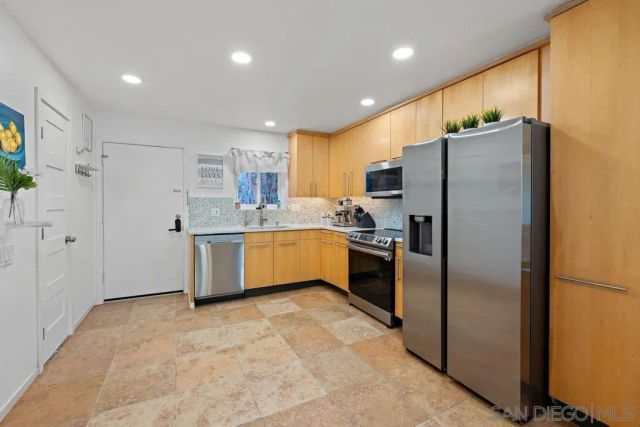 a kitchen with stainless steel appliances a refrigerator sink and cabinets