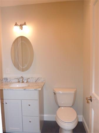 447 Washington Street, Unit 3 Brookline, MA 02446 - Photo 12 of 20 a bathroom with a toilet sink vanity and mirror