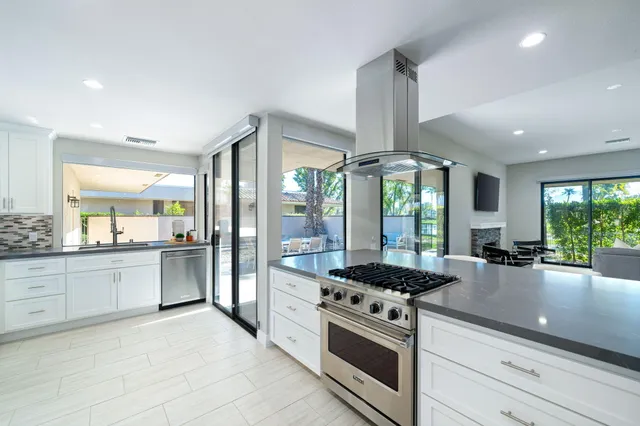 a kitchen with stainless steel appliances granite countertop a stove and a sink